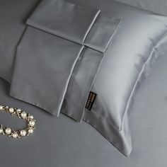 a close up of a pillow and bracelet on a bed