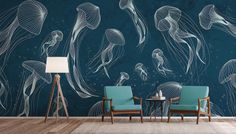 a living room with blue chairs and wallpaper that has jellyfish on it,