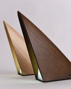 two wooden triangular shaped objects on a white surface