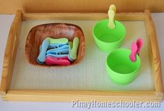 a wooden tray with plastic toys in it