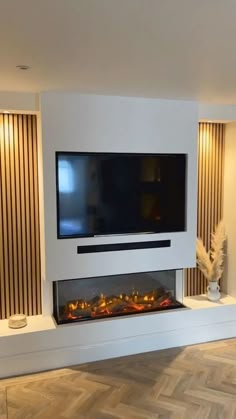 a flat screen tv mounted to the side of a wall next to a fire place