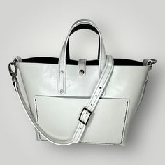 The Taylor Handbag is the epitome of classic and timeless style. It is crafted from high-quality Italian leather with elegant white edging. It features both hand and shoulder straps, providing versatility for any occasion. Convenient inside and outside pockets offer ample storage for all your essentials. Measures: 42cm wide x 27cm long x 13cm deep Modern Box Bag With Detachable Handle For Errands, Modern Rectangular Satchel For Errands, Classic Top Handle Box Bag For On-the-go, White Luxury Tote Box Bag, Luxury White Tote Box Bag, Classic Bags With Detachable Strap For On-the-go, Classic Box Bag With Leather Handles For Errands, Luxury White Bucket Bag With Top Carry Handle, Luxury White Bucket Bag With Top Handle