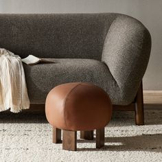 a chair and ottoman in a living room with carpet on the floor next to it