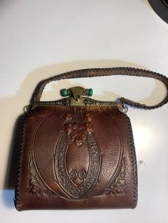 Vintage 1917 leather purse.  Have only found one purse like this with green clasp.  Glasp works great.  Piping on strap needs to be repaired hence the price adjustment.  Inside is immaculate. Compact Leather Bags For Formal Occasions, Leather Evening Bag With Coin Pocket, Vintage Brown Wallets With Leather Lining, Vintage Brown Wallet With Leather Lining, Vintage Brown Crossbody Wallet, Leather Evening Coin Purse With Coin Pocket, Leather Coin Purse With Coin Pocket For Evening, Compact Brown Leather Bag, Vintage Leather Shoulder Bag With Engraving