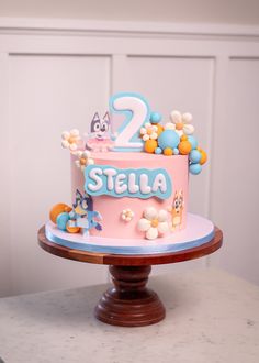 a pink and blue two tiered birthday cake