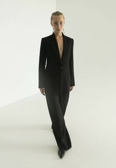 a woman in a black suit and heels