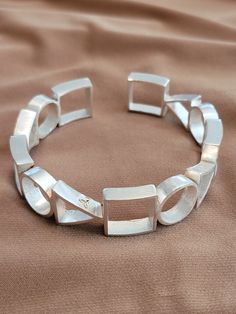 The bracelet is geometric style with .25 inch circles, squares, and triangles.  Solid 925 silver filled. Cool Silver Bracelets, Silver Cuff Bracelet For Women, Modern Sterling Silver Cuff Bracelet Bangle, Sterling Silver Jubilee Cuff Bracelet, Modern Sterling Silver Jubilee Bracelet With Rectangular Links, Modern Sterling Silver Bangle Bracelet, Contemporary Sterling Silver Bracelet, Elegant Silver Square Bracelet, Modernist Geometric Jewelry For Formal Occasions