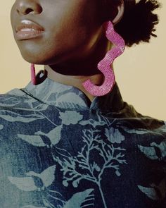 a woman with large pink earrings on her ear