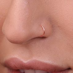 a woman's nose with a tiny nose ring on top of her nose,