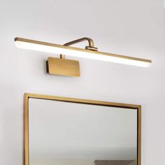 a bathroom with a mirror and a light on the wall next to it's reflection