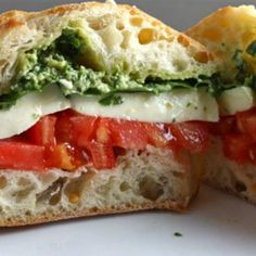 a close up of a sandwich with tomatoes and mozzarella on it, cut in half