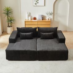 a black couch sitting on top of a white rug