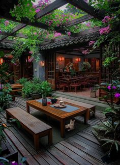 a wooden table sitting on top of a wooden floor covered in flowers and greenery