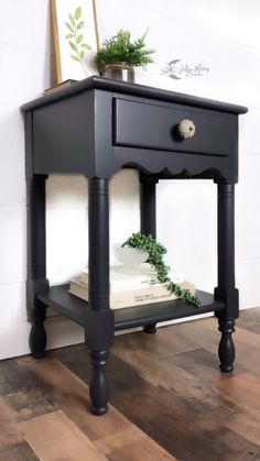 a black end table with books and plants on top