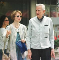 an older man and woman walking down the street with shopping bags in their hands,