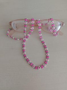 a pair of glasses with pink and white beads on them