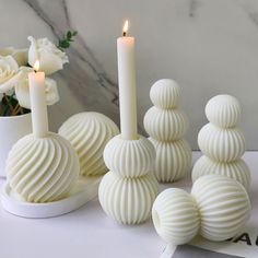 some white candles sitting on top of a table