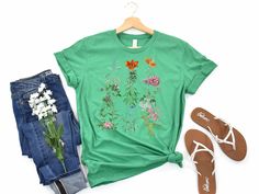 "Embrace the bohemian allure with our stunning boho t-shirt adorned with blooming flowers! This nature-inspired design brings a touch of whimsy and elegance to your wardrobe, perfect for those who cherish free-spirited style. Let the floral magic bloom with every step you take!" Product Info:  This shirt is Bella Canvas Light fabric Made in the USA Sizing Runs true size Unisex Fit Shipping and Delivery  Ships from the USA in normally 3-4 days. Once shipped you will receive a tracking number REFU Multicolor Bohemian Relaxed Fit T-shirt, Hippie Multicolor T-shirt For Spring, Bohemian Multicolor T-shirt For Vacation, Green Bohemian T-shirt For Summer, Bohemian Crew Neck T-shirt For Summer, Summer Crew Neck T-shirt With Plant Print, Spring Bohemian Crew Neck Tops, Multicolor Bohemian T-shirt For Spring, Bohemian Floral Print Tops For Garden Party