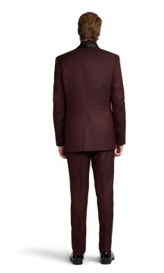 A slim burgundy tuxedo with one button and a shawl lapel. Tailored Burgundy Suits For Fall, Semi-formal Burgundy Blazer With Suit Collar, Burgundy Blazer With Suit Collar For Semi-formal Occasions, Semi-formal Burgundy Suit For Fall, Tailored Burgundy Blazer For Semi-formal Occasions, Burgundy Semi-formal Blazer With Suit Collar, Classic Burgundy Suits For Fall, Classic Tailored Burgundy Blazer, Classic Burgundy Blazer With Suit Collar