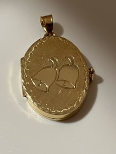 This hand-made oval locket is as sentimental and unique as it gets. It is a perfect baby shower or a Communion present. It is made of 14 karat gold. It is both beautiful and functional. Most lockets can hold 2 pictures but this one can hold 4 special photos close to your, or your loved one's heart! The photos are easy to slip through slots at top of locket. It is hard to match the workmanship of this locket and it's engraving. It was crafted by a very talented jeweler in the NYC jewelry district between 1970 - 1980. Lockets are his legacy and his remaining inventory is being sold on this site. Most are one of a kind and will not be available after it is sold. The best jewelers are in awe of the workmanship and you will always get compliments. This precious locket and can easily become a he Oval Charms Jewelry For Keepsake, Oval Keepsake Jewelry With Charms, Keepsake Oval Charms Jewelry, Oval Keepsake Jewelry Charms, Gold Oval Heirloom Locket Necklace, Gold Oval Link Locket Necklace For Anniversary, Gold Oval Locket Necklace As A Gift, Classic Oval Locket Necklace Stamped 14k, Personalized Oval Locket Necklace In Yellow Gold