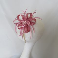 This is an attractive and eye catching sinamay loop fascinator in shades of dusky rose pink. It is made to order and will take 5-7 days, plus delivery time. Created with a small bow loop of dusky pink sinamay bias binding..  Complemented with dusky pink curled biot feathers and finished with a dusky pink satin ribbon ruffle, and a cluster of pale pink glass pearls. Also available with a colour highlight including, mint green, burgundy, Ivory, Lavender, Lemon, Navy, Aqua, Grey, Latte and Orange. Elegant Pink Hair Accessories For Royal Ascot, Elegant Pink Headband Fascinator, Elegant Pink Hair Accessories For Kentucky Derby, Elegant Pink Hair Accessories For Races, Pink Flower Fascinator For Wedding, Elegant Pink Fascinator As A Gift, Elegant Pink Fascinator For Gifts, Elegant Pink Fascinator For Gift, Elegant Pink Fascinator Gift