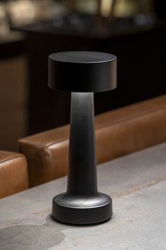 a black table lamp sitting on top of a counter