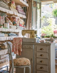 a sewing machine sitting on top of a wooden table next to a dresser and chair