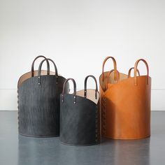 three different colored leather bags sitting on top of a table