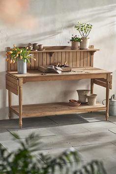 a wooden bench with potted plants on it