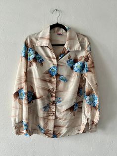 Vintage tan, brown and blue silky floral print pointed collar button up. Includes button sleeve cuffs. Unlined. DETAILSLabel: PykettesCondition: Excellent SIZE & MEASUREMENTSBest Fits: M/LLength: 31"Bust: 42"Waist: 38"Sleeve: 24"Shoulder: 16" Includes Free US Shipping Retro Long Sleeve Beach Shirt, Retro Long Sleeve Beach Tops, Retro Long Sleeve Shirt For Beach, Beach Retro Long Sleeve Blouse, Vintage Button-up Beach Top, Vintage Long Sleeve Beach Shirt, Vintage Beach Tops With Button Closure, Vintage Long Sleeve Shirt For Beach, Vintage Long Sleeve Shirt For The Beach