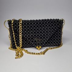 The Lena Bag is a striking accessory crafted from solid glossy beads in a distinctive circle shape. The black beads exhibit a captivating glossy finish that shines under light, making the Lena Bag a bold and elegant choice for any occasion. Elegant Black Beaded Bags, Luxury Black Beaded Evening Bag, Gift Black Beaded Shoulder Bag, Elegant Black Beaded Clutch, Elegant Party Bag With Black Beads, Elegant Party Bags With Black Beads, Elegant Evening Bags With Black Beads, Elegant Evening Bag With Black Beads For Party, Black Shoulder Bag With Chain Strap For Events