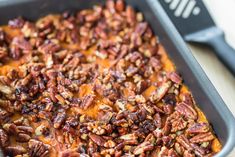 a casserole dish with pecans on top