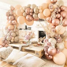 a living room filled with lots of balloons and flowers on top of a wooden floor