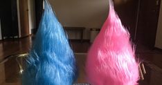 two pink and blue wigs sitting on top of a table