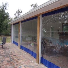 a patio covered in blue tarp and chairs next to an outside dining room area