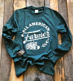 All American Farmer T-Shirt Show your support for our Farmers or if you are one wear it to show your pride. - Long Sleeve - Hunter Green - Graphic on Front - Unisex - Adulting Sizing - 52% Cotton/48% Polyester ***Cuff sold separately 4h Shirts, Agriculture Shirt, Boho Tshirts, Farm Family, Farmer Shirt, Showing Livestock, Cute Country Outfits, Boutique Ideas, Cute Shirt Designs