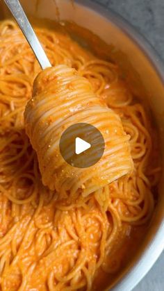 spaghetti being cooked in a pot with a ladle