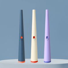 three different colored toothbrushes sitting on top of a white table next to each other