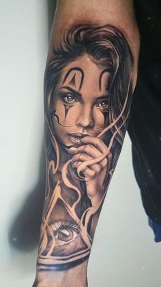 a woman's arm with an evil face and eyeball tattoo on the left forearm