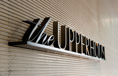 the upperhouse sign is mounted on a wall