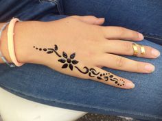 a woman's hand with a black flower tattoo on it