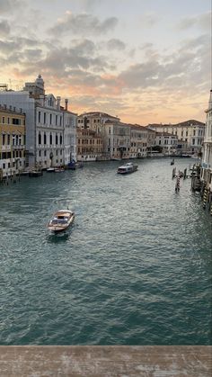 several boats floating in the water near buildings