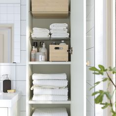 the shelves in this bathroom are filled with white towels and other bath products, along with toiletries