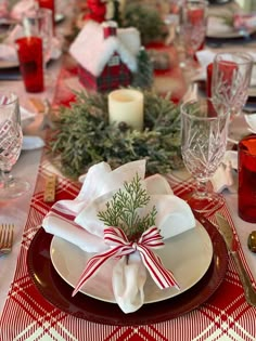 a table set for christmas dinner with red and white place settings