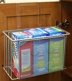 a metal basket holding four boxes of toilet paper on top of a wooden countertop