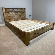 a bed frame made out of wooden planks in a room with carpeted flooring