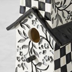 a birdhouse with a black and white checkered design on it's roof