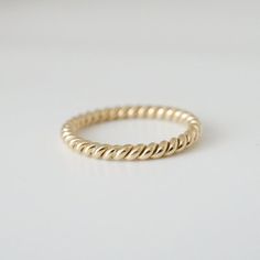 This is our Brockton Signature 2 mm rope ring in solid 14k yellow gold.  It is handmade to order in Toronto.  We love it because it is so versatile.  It looks great on its own and pairs nicely with an engagement ring or classic ring stack.  Also available for custom order in different widths.  Please ask for details.  MATERIALS14k yellow gold.SIZEThe ring will be custom made in your size.  Size 6 ring is in-stock and available and ready to ship immediately.  Additional fee may apply larger sizes Braided Gold Wedding Band, Modern Twist Yellow Gold Twisted Stackable Rings, Minimalist Twisted Yellow Gold Ring, Twisted 14k Gold Rings With Modern Twist, Modern Twist 14k Gold Twisted Ring, Minimalist Twisted Gold Rings, 14k Gold Twisted Rings For Gift, Twisted 14k Yellow Gold Stackable Rings, Twisted Yellow Gold Jewelry For Everyday