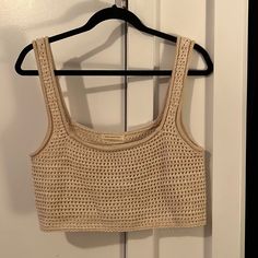 a crop top hanging on a hanger in front of a door