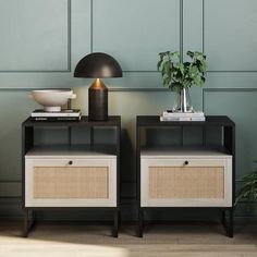 two black and white nightstands next to each other in front of a green wall